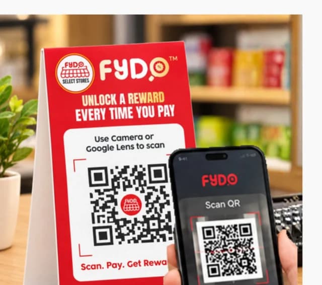 A customer scanning a static QR code on a counter stand with a phone.
